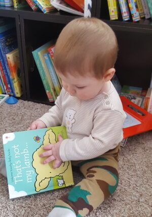 photo of a child with brown hair reading the Usborne That's Not My Lamb book