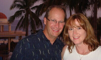 photo of Tom & Becky Dean with palm trees in the background in the Mexican Riveria on a free trip with Usborne Books & More, now known as PaperPie.