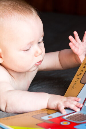photo of a baby with brown hair reading the Usborne That's Not My Tractor