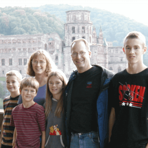 photo of Tom & Becky Dean with their 4 children standing in front of a castle in Heidelberg, Germany