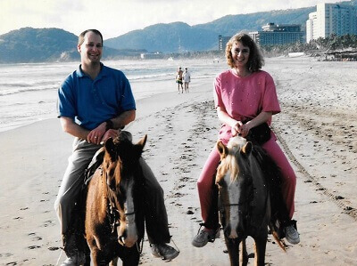 Tom & Becky Dean on horses on the beach in Acapulco